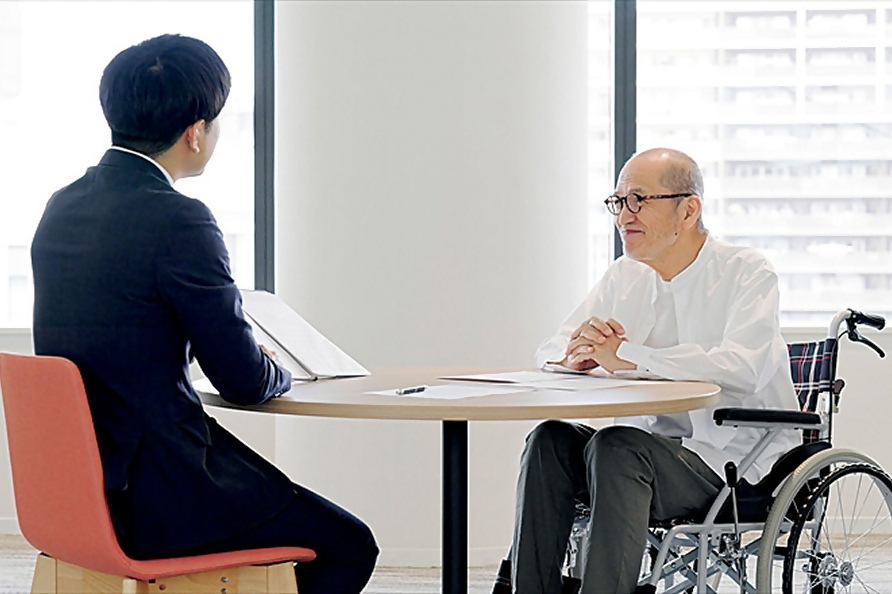 写真：車いすの男性が職員に相談する様子